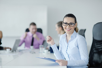 Image showing business woman standing with her staff in background