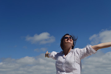 Image showing happy young woman with spreading arms to sky