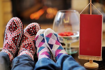 Image showing Young romantic couple relax on sofa in front of fireplace at hom