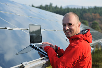 Image showing engineer using laptop at solar panels plant field