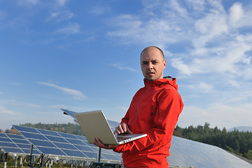 Image showing engineer using laptop at solar panels plant field