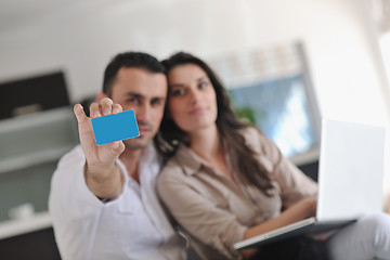 Image showing joyful couple relax and work on laptop computer at modern home