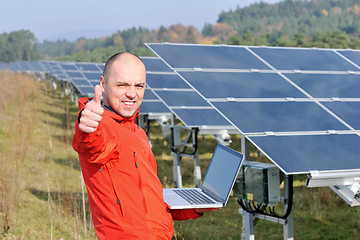 Image showing engineer using laptop at solar panels plant field