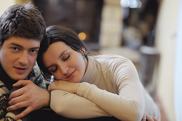 Image showing Young romantic couple sitting and relaxing in front of fireplace