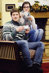 Image showing Young romantic couple relax on sofa in front of fireplace at hom