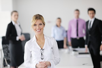 Image showing business woman standing with her staff in background