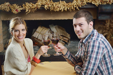 Image showing Young romantic couple sitting and relaxing in front of fireplace