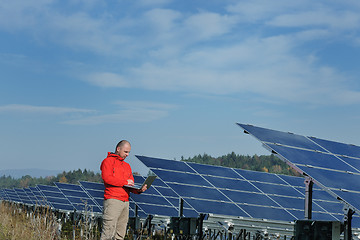 Image showing engineer using laptop at solar panels plant field