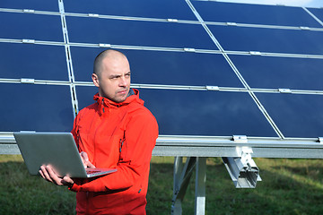 Image showing engineer using laptop at solar panels plant field