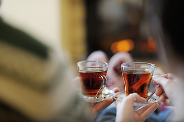 Image showing Young romantic couple sitting and relaxing in front of fireplace