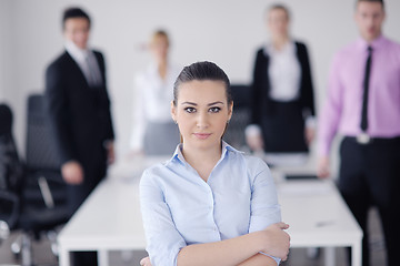 Image showing business woman standing with her staff in background