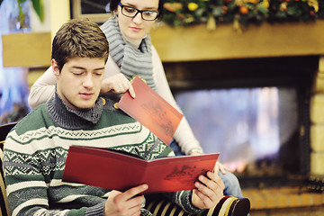 Image showing Young romantic couple sitting and relaxing in front of fireplace