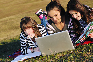 Image showing group of teens working on laptop outdoor