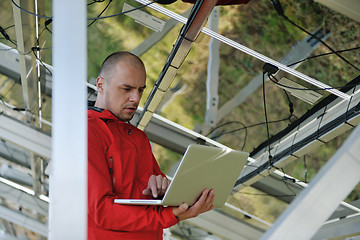 Image showing engineer using laptop at solar panels plant field