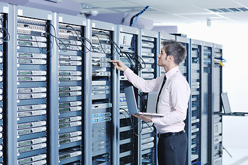 Image showing businessman with laptop in network server room