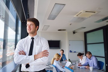 Image showing business man  on a meeting in offce with colleagues in backgroun