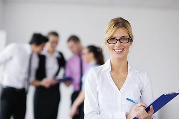 Image showing business woman standing with her staff in background