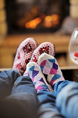 Image showing Young romantic couple relax on sofa in front of fireplace at hom