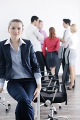 Image showing business woman standing with her staff in background