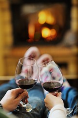 Image showing Young romantic couple sitting on sofa in front of fireplace at h