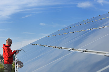 Image showing engineer using laptop at solar panels plant field