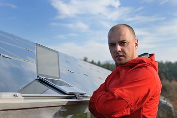 Image showing engineer using laptop at solar panels plant field