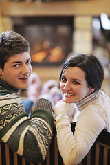 Image showing Young romantic couple sitting and relaxing in front of fireplace