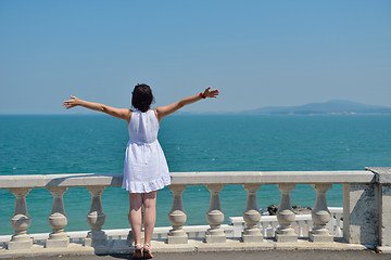 Image showing happy young woman with spreading arms to sky