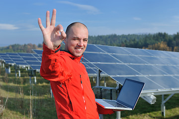 Image showing engineer using laptop at solar panels plant field