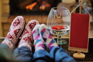 Image showing Young romantic couple sitting and relaxing in front of fireplace