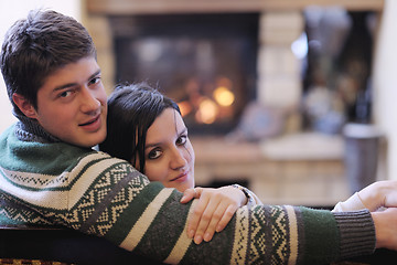 Image showing Young romantic couple sitting and relaxing in front of fireplace