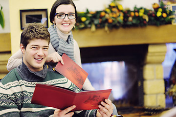 Image showing Young romantic couple sitting and relaxing in front of fireplace