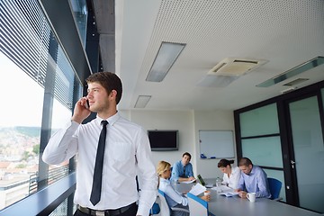 Image showing business man  on a meeting in offce with colleagues in backgroun