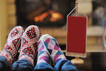 Image showing Young romantic couple sitting and relaxing in front of fireplace