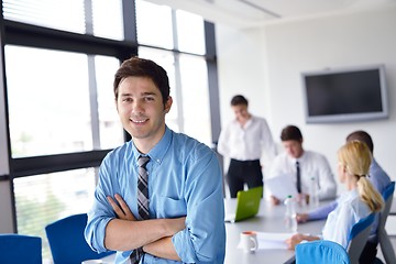 Image showing business man  on a meeting in offce with colleagues in backgroun