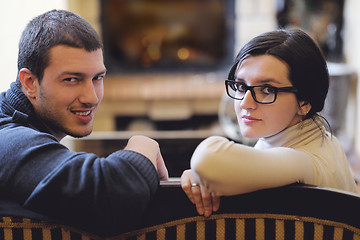 Image showing Young romantic couple sitting and relaxing in front of fireplace