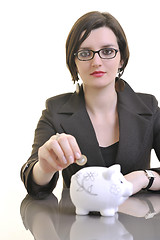 Image showing business woman putting money coins in piggy bank