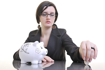 Image showing business woman putting money coins in piggy bank