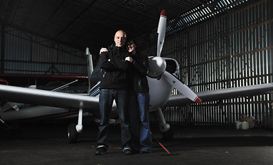 Image showing happy young couple posing in front of private airplane