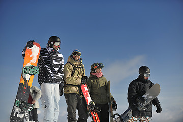 Image showing snowboarders group relaxing and enjoy sun