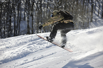 Image showing freestyle snowboarder jump and ride