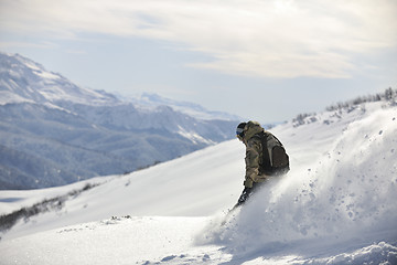 Image showing freestyle snowboarder jump and ride