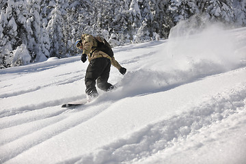 Image showing freestyle snowboarder jump and ride