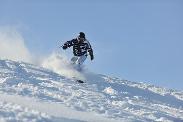 Image showing freestyle snowboarder jump and ride