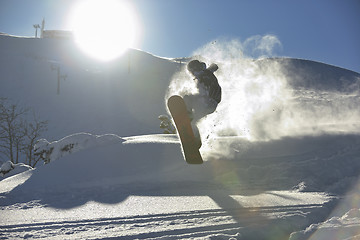 Image showing freestyle snowboarder jump and ride