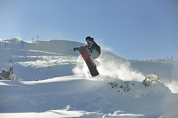 Image showing freestyle snowboarder jump and ride