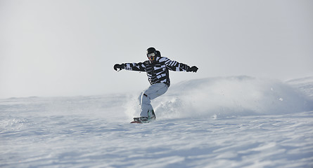 Image showing freestyle snowboarder jump and ride