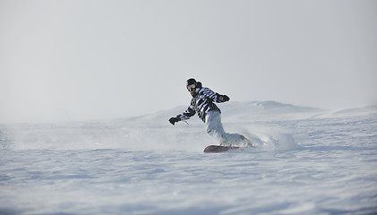 Image showing freestyle snowboarder jump and ride