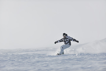 Image showing freestyle snowboarder jump and ride