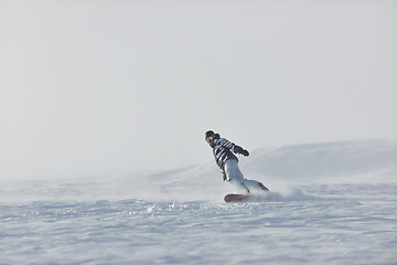 Image showing freestyle snowboarder jump and ride